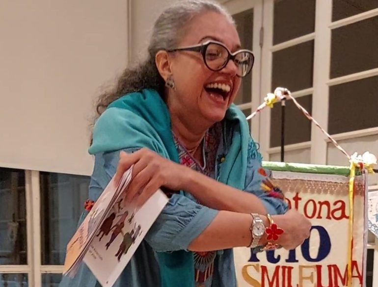 Maratona Rio de Mil e Uma Histórias 2022, 3 Histórias de Duaia, de Maria do Rosário (Duaia) de Assumpção Braga, uma produção Realizamos Artes. Duaia faz o gesto de abraçar a neta e sorri feliz.