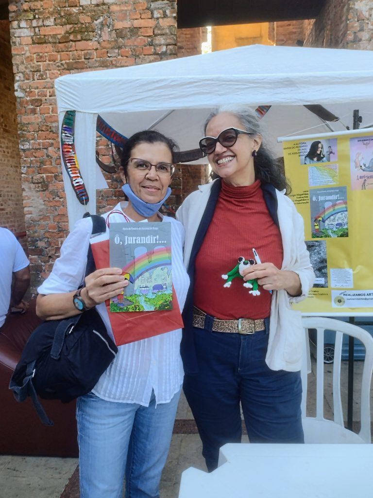 A bailarina Tatiana de Faria segura seu exemplar autografado do livro "O, Jurandir!..." abraçada à autora Duaia Assumpção, que segura um dos sapinhos do livro "O Sapo e a Poça"