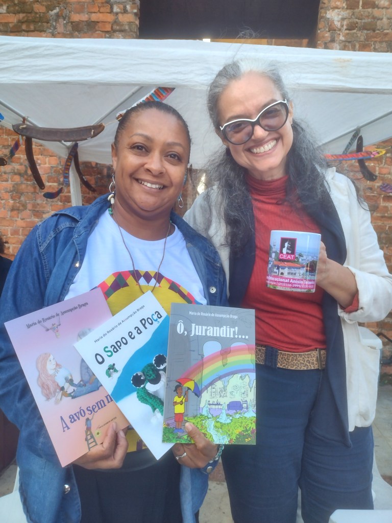 Flist 2022, Simone do CEAT, organizador da FLIST, recebe os livros de Duaia no Pré-lançamento dos livros de Maria do Rosário (Duaia) de Assumpção Braga pela Realizamos Artes no Parque das Ruínas, RJ. E Duaia recebe a caneca de agradecimento do CEAT